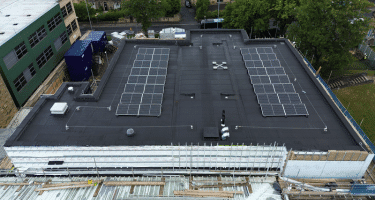 Bauder roofing system with tapered insulation and PV solar modules on school roof installed by experienced Bauder Installers.