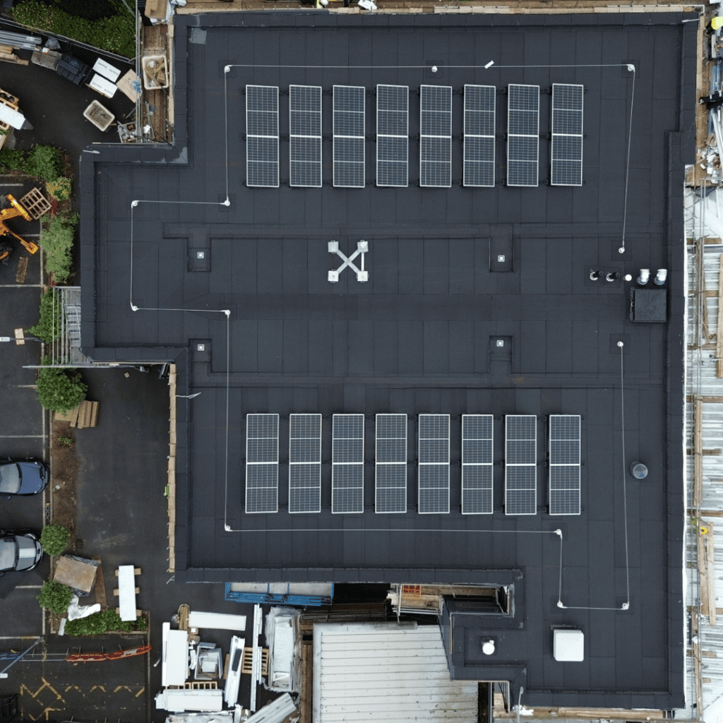 Drone view of flat roof installation with Bauder solar PV panels and waterproofing by D&D Roofing Ltd on a commercial building in Yorkshire